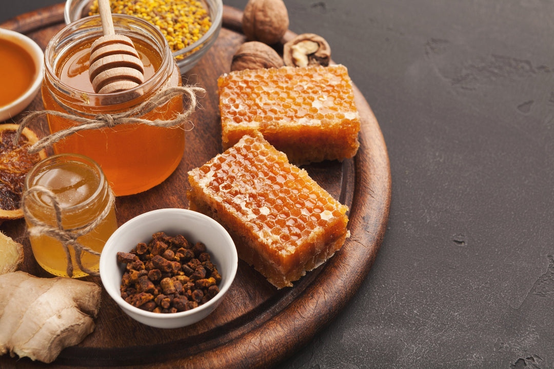 Various types of honey on wooden platter, closeup