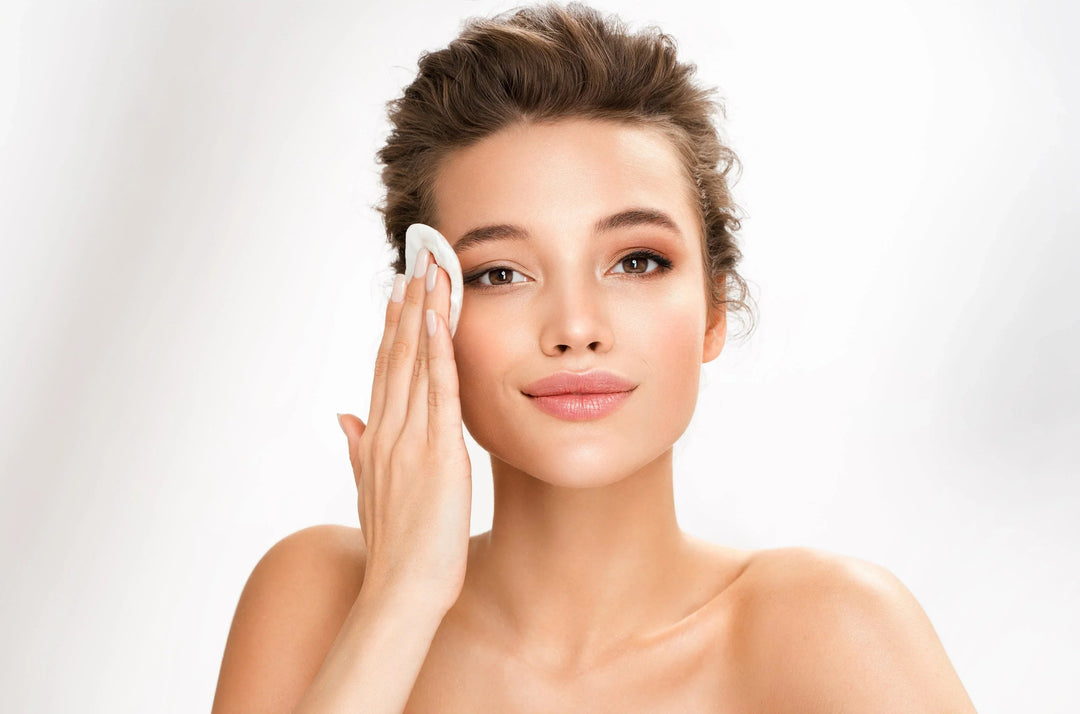 Woman gently cleansing her glowing skin with cotton pad, promoting natural skincare and radiance