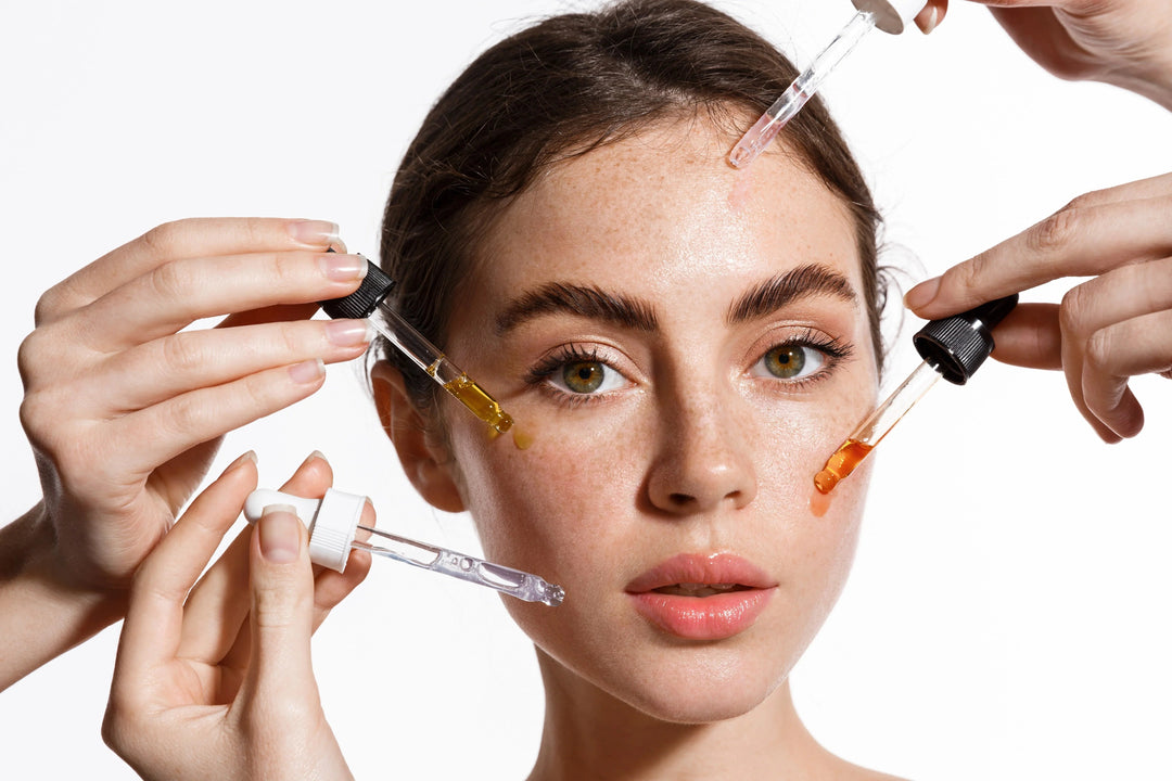Close-up of woman with clear skin applying different colorful skincare serums from droppers for hydration and radiance