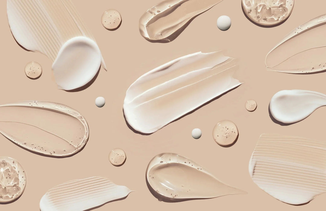 Artistic smears and droplets of clean beauty skincare creams and serums on a beige background