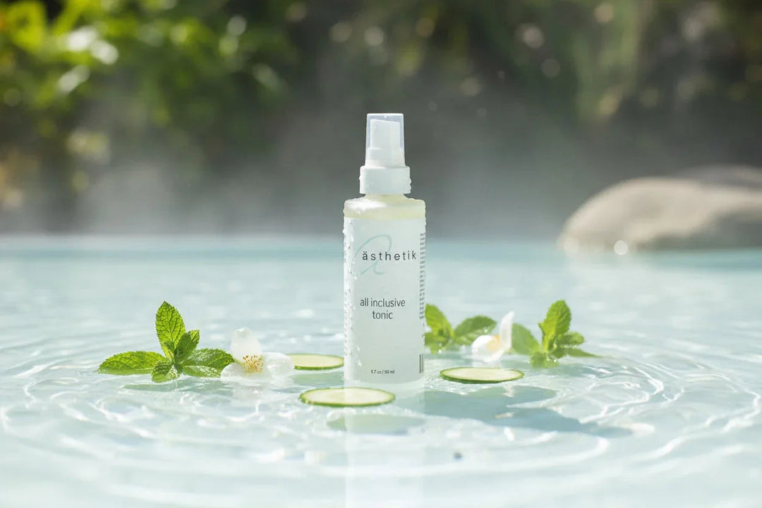 ästhetik all inclusive tonic toner bottle in water with cucumber slices, mint, and white flowers