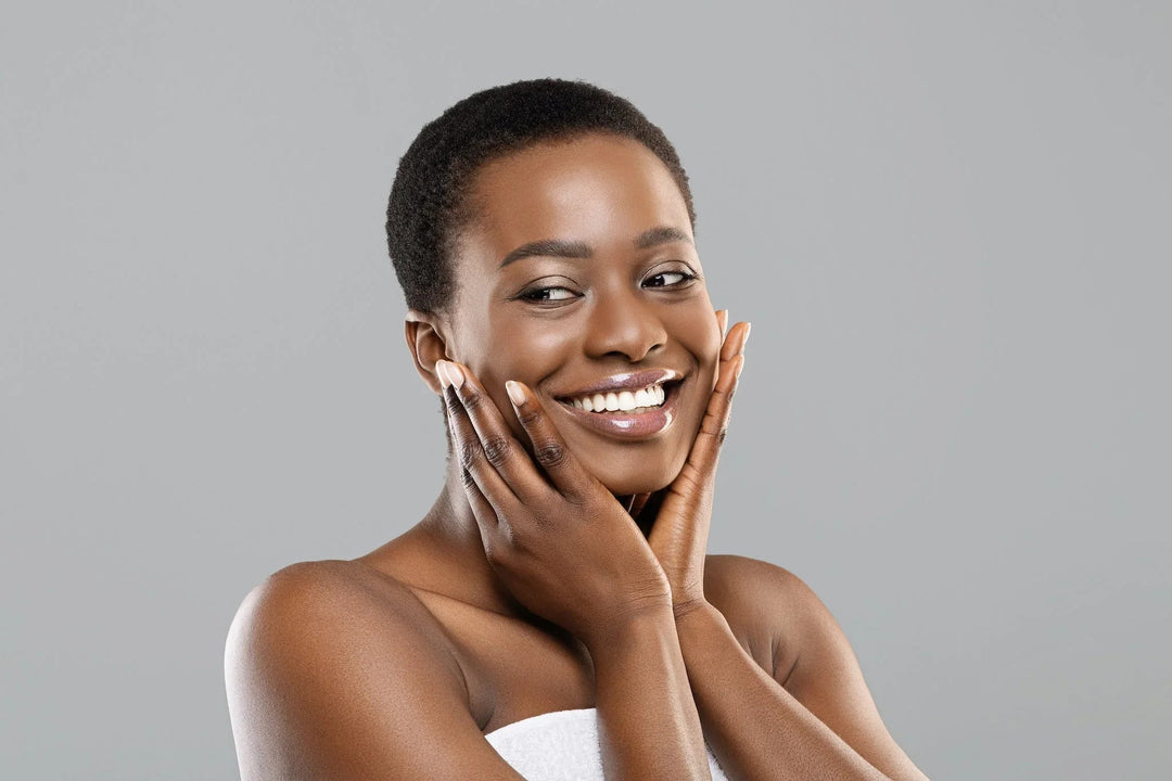 Smiling woman with glowing skin gently touching her face, clean beauty skincare concept