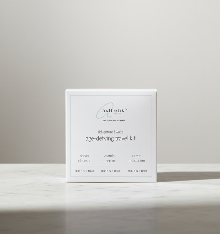 ästhetik age-defying travel kit with cleanser, serum, and moisturizer on a marble surface