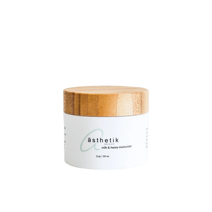 ästhetik skincare milk & honey moisturizer in a white jar with a bamboo lid