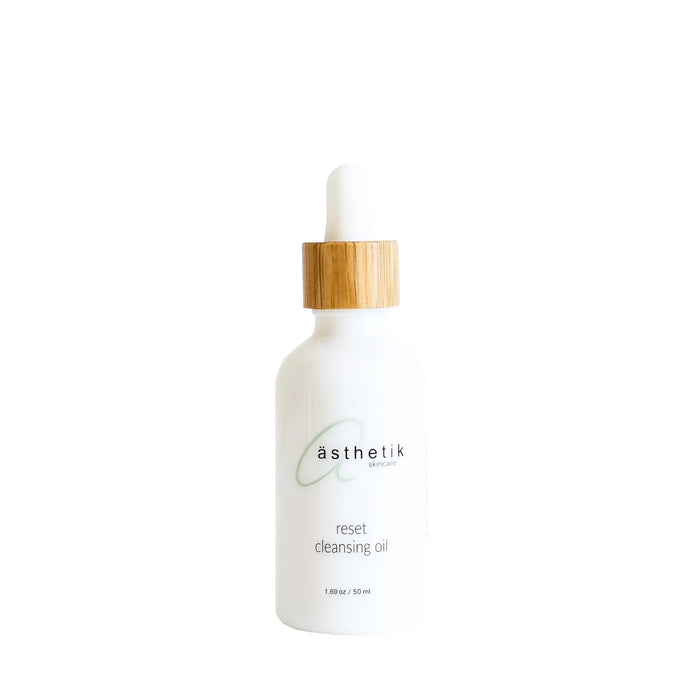 ästhetik reset cleansing oil in a white bottle with a wooden dropper cap