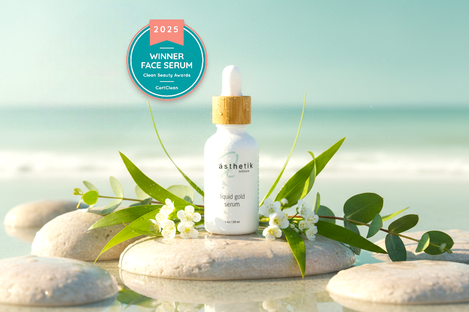 White face serum bottle with gold cap on a stone surrounded by greenery and flowers, with a 2025 winner badge in the corner.