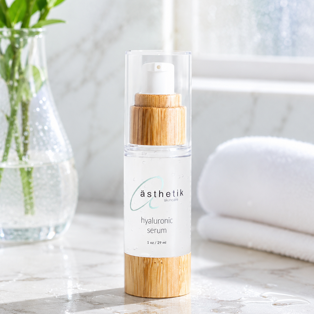 asthetik hyaluronic serum bottle on a marble surface with a blurred background