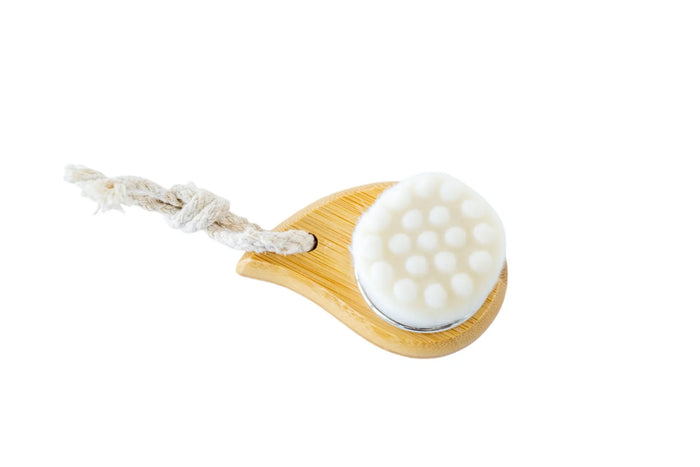 Eco-friendly bamboo body brush with white scrubbing bristles and a natural rope handle.