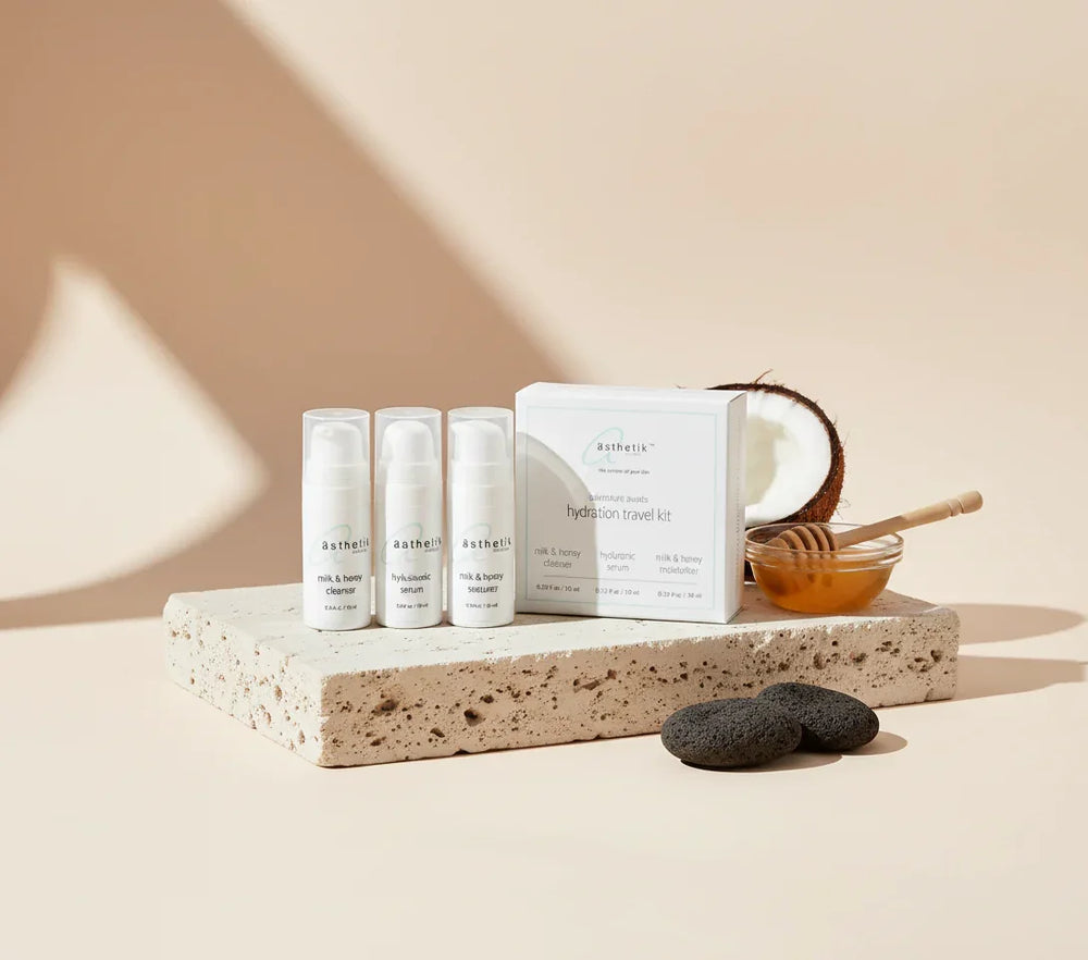 Skincare products and tools on a stone surface with a neutral background