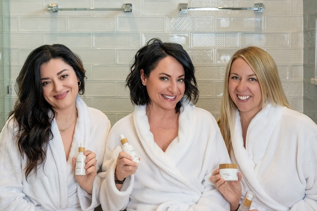 Three women sharing a skincare moment with ästhetik products.
