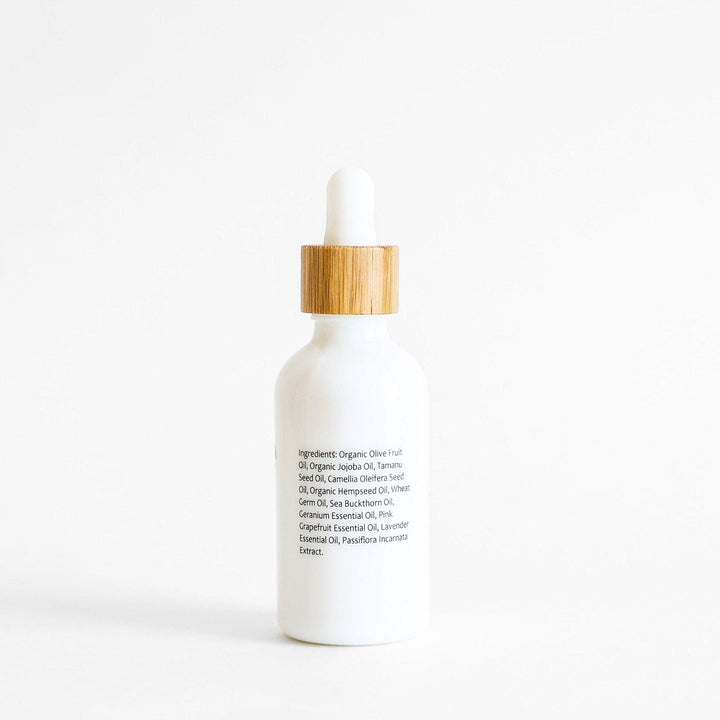 Elegant botanical cleansing oil in minimalist white bottle with bamboo dropper cap
